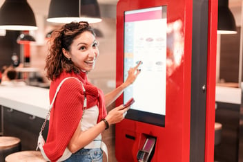 girl orders fast food at self order kiosk