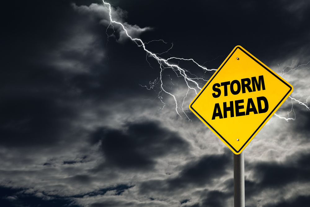 thunderstorm behind a signpost warning about storms